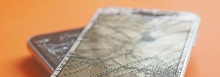 Nahaufnahme eines Smartphones mit komplett gesprungenem Display – typischer Sachschaden am fremden Handy, den eine private Haftpflichtversicherung abdecken kann.